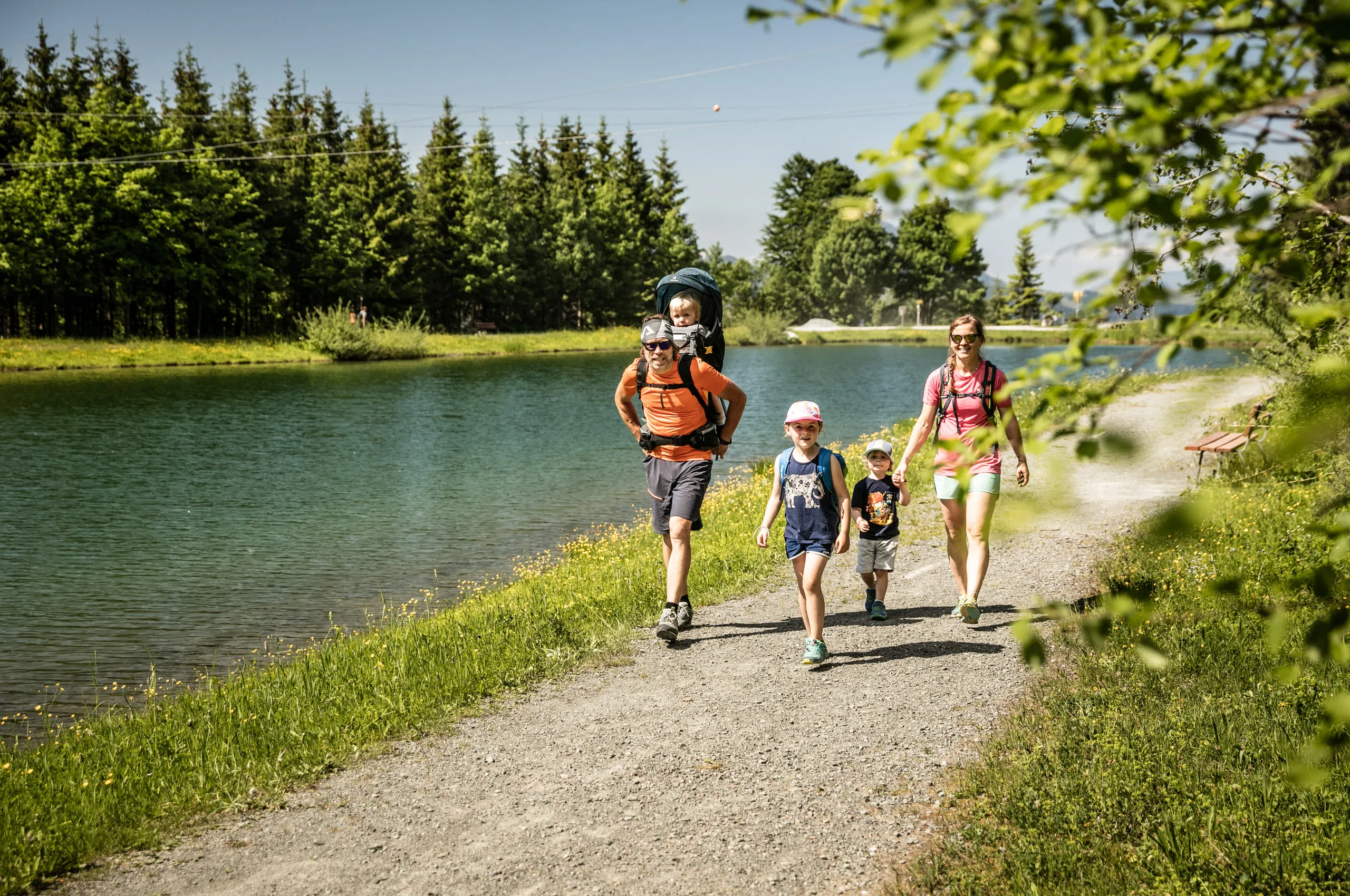 Familie wandert entlang eines Gewässers bei St. Johann