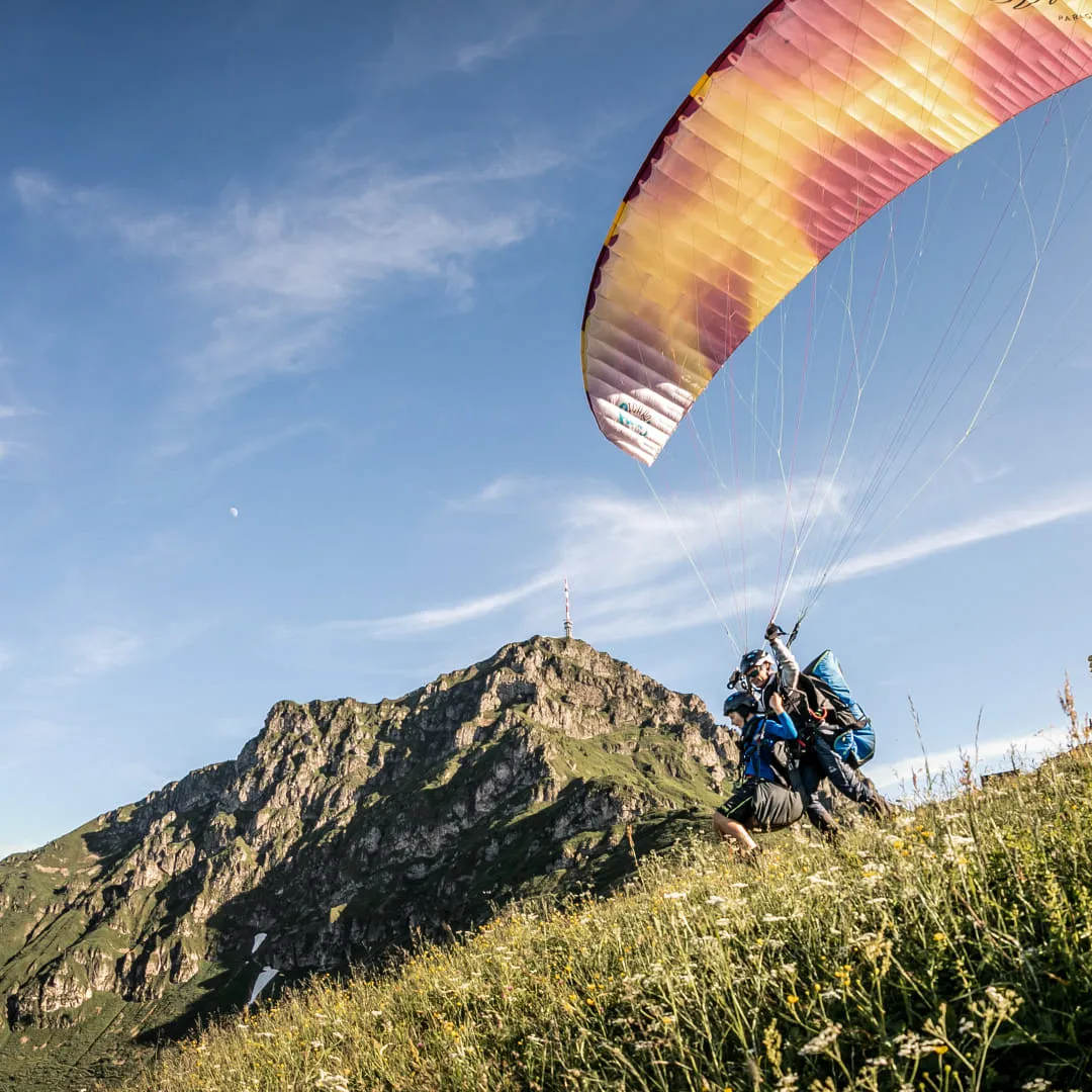 Paragleiter starten vor den Bergen von St. Johann.