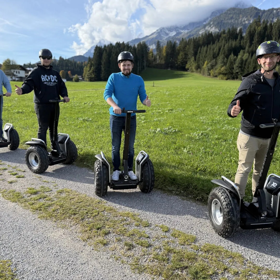 Fünf Personen auf Segways in einer grünen Landschaft