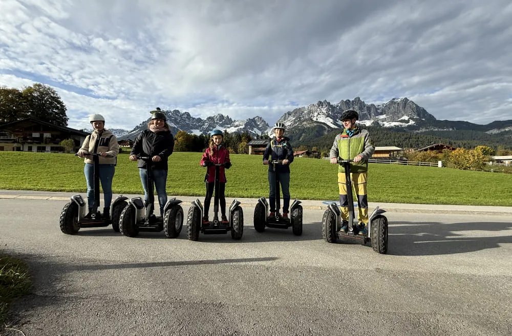 Gruppe von fünf Personen auf Segways vor Bergen