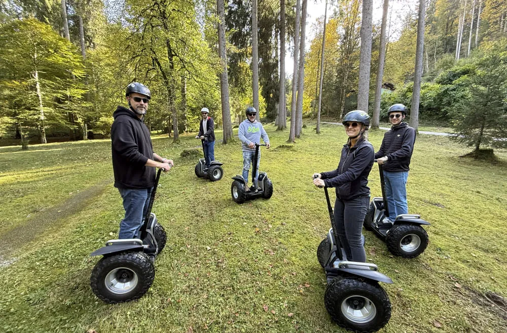 Gruppe von fünf Personen auf Segways im Park