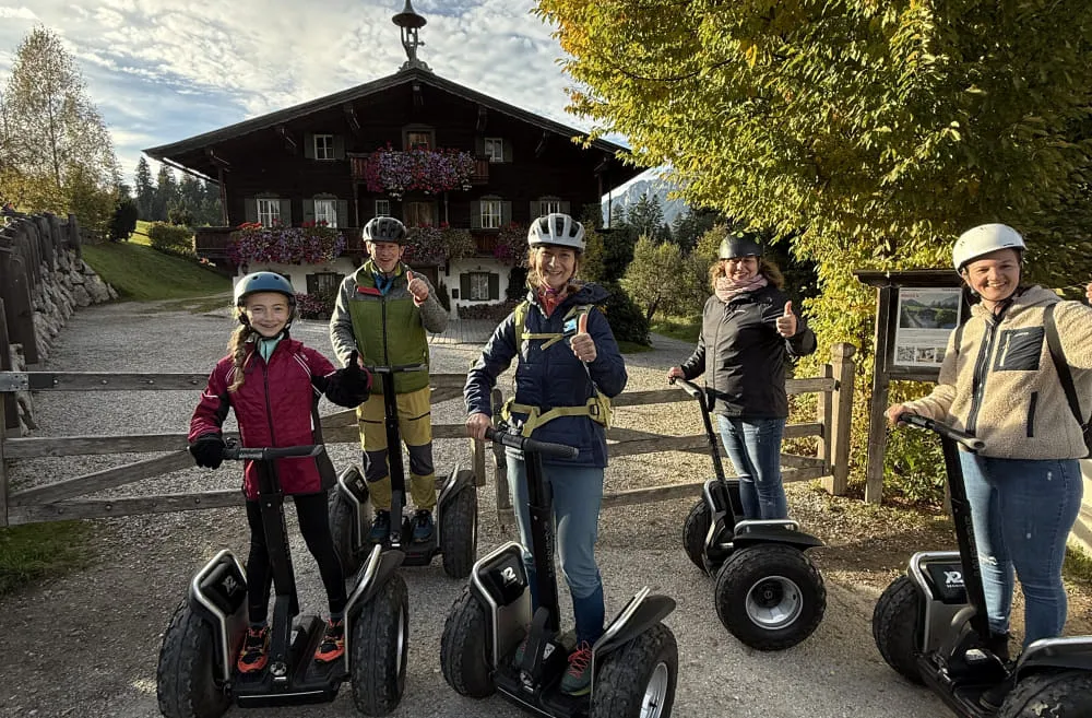 Gruppe von sechs Personen mit Segways vor einem Gebäude