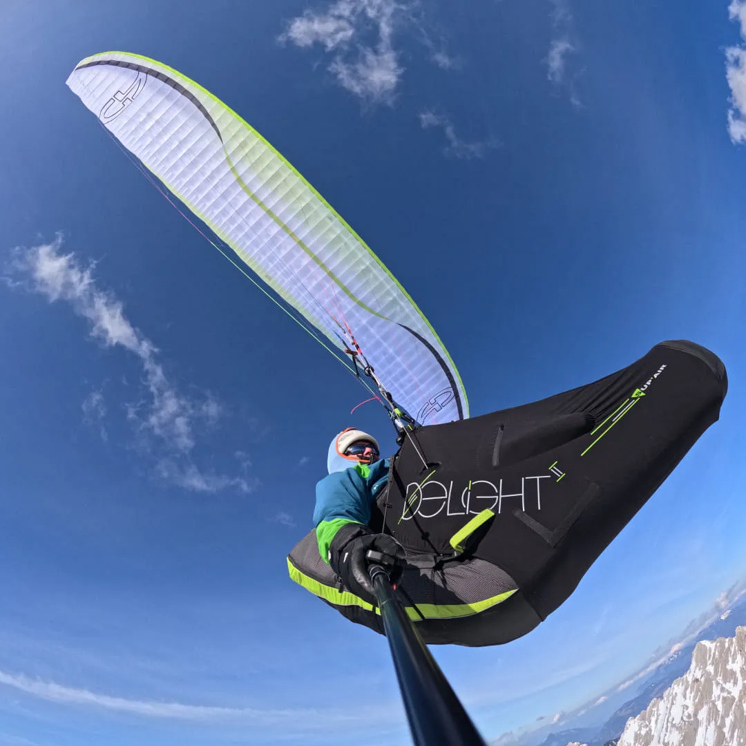 Person beim Paragleiten mit einer bunten Gleitschirm
