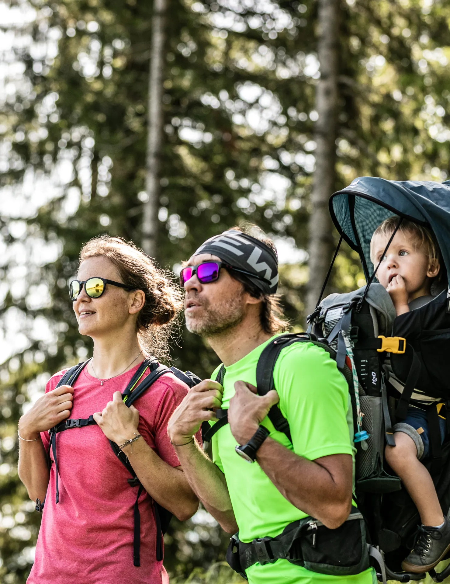 Wanderer mit Kind auf dem Rücken im Wald